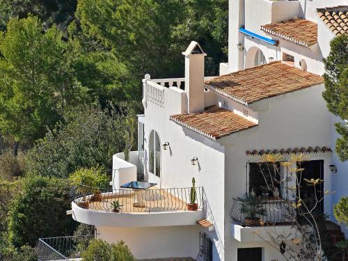 a white house with a balcony and trees at Apartment La Colina by Interhome in Rada de Moraira