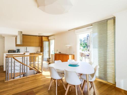 une cuisine et une salle à manger avec une table et des chaises blanches dans l'établissement Apartment Cap Marine-3 by Interhome, à Cavalaire-sur-Mer