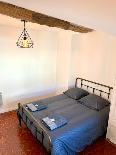 - une chambre dotée d'un lit avec des draps bleus et un lustre dans l'établissement Appartement de charme au cœur de Grasse, à Grasse