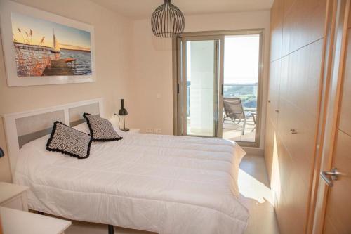 聖胡安德洛斯特洛斯的住宿－Mundo de sol golf et plage，一间带一张白色大床的卧室和一个阳台