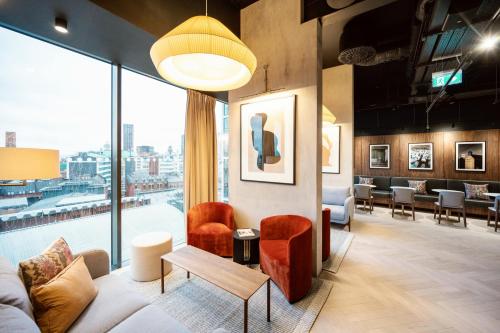 a living room filled with furniture and a large window at Wilde Aparthotels Manchester St. Peters Square in Manchester