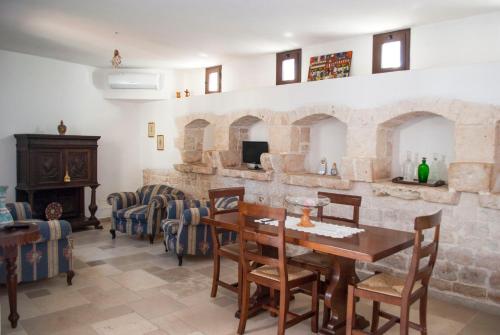 a living room with a table and chairs and a fireplace at Agriturismo Antonelli Piangevino in Monopoli