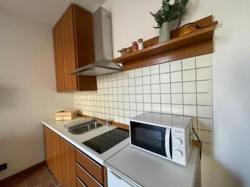 a kitchen with a sink and a microwave at Casa Desi in Baura
