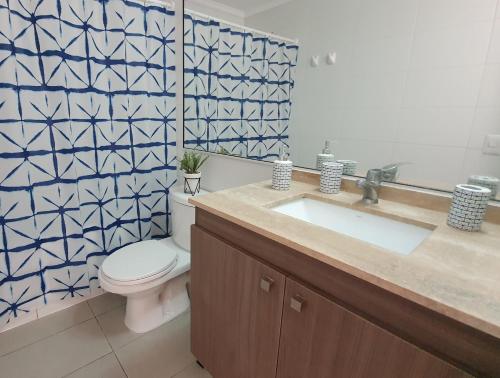 y baño con aseo blanco y lavamanos. en Antofagasta Sunset - Amplio Departamento con Home Office y Vista Mar, en Antofagasta