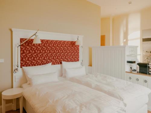 a bedroom with a large white bed with a red headboard at Bad Hotel Überlingen in Überlingen