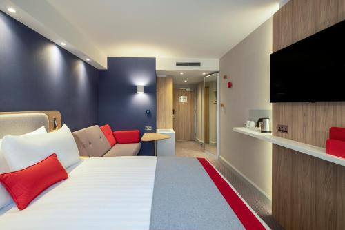 a hotel room with a bed and a flat screen tv at Holiday Inn Express Cambridge West - Cambourne by IHG in Cambridge