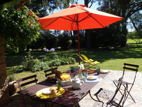 una mesa de picnic con una sombrilla roja en el patio en Holiday Home Kerhellec by Interhome, en Plouharnel