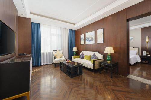 a living room with a couch and a tv at OBOR Hotel in Ürümqi