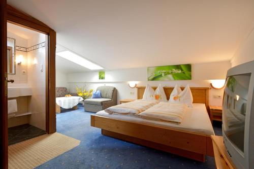 ein Schlafzimmer mit einem Bett und ein Wohnzimmer in der Unterkunft Alpenresidenz Unterrainer in Ellmau