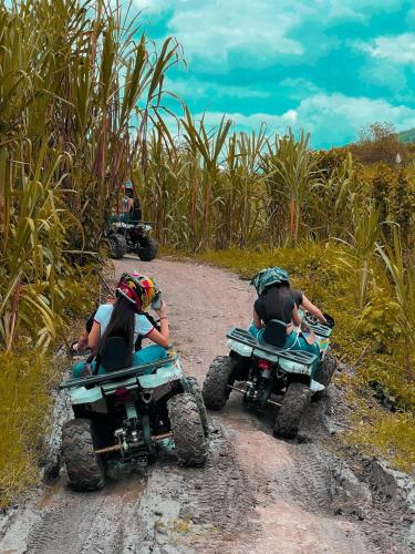 two people riding on atvs on a dirt road at Santuario Luxury Eco Hotel in Villeta