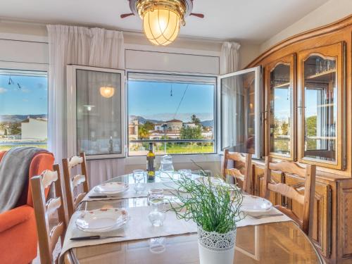 a dining room with a table and chairs and windows at Apartment Sol i Canal by Interhome in Empuriabrava