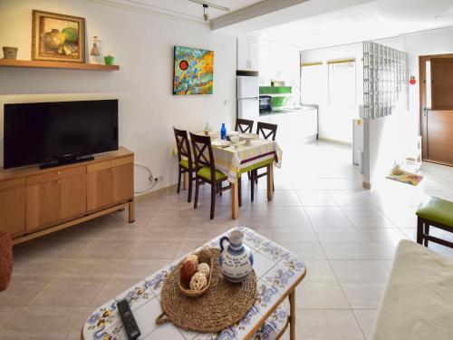 a living room with a television and a dining room at Apartment Caseta Blanqueta by Interhome in Denia