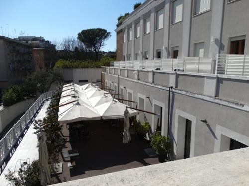 a balcony with white umbrellas on a building at Hotel Il Cantico St. Peter in Rome