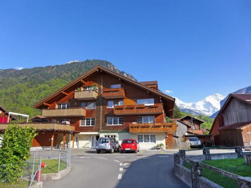 a large wooden building with cars parked in front of it at Apartment Carina by Interhome in Wilderswil