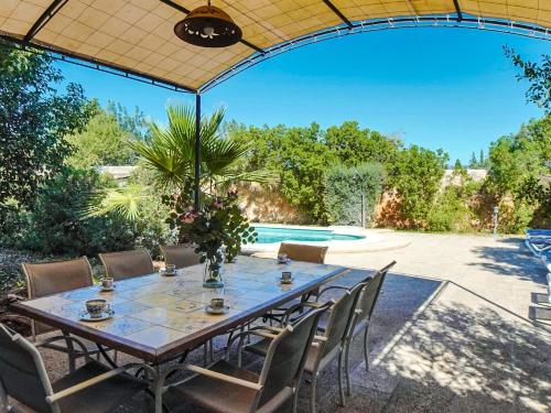 a table and chairs in a patio with a pool at Holiday Home Cas Frare ESB100 by Interhome in Establiments