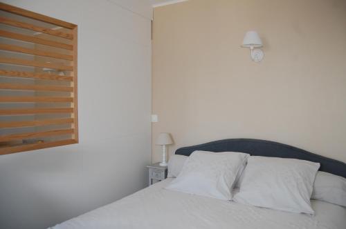 a bedroom with a bed with white sheets and a window at LE SEUIL in Chartres