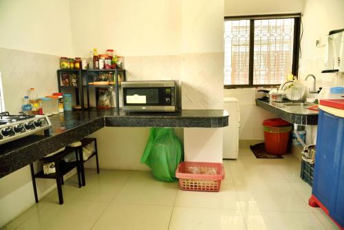 a kitchen with a counter with a microwave on it at GRUHAM SOJOURN HOMESTAY in Guwahati