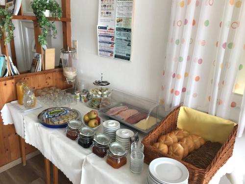 einen Tisch mit Essen und einen Korb Brot in der Unterkunft Gästehaus & Weingut Klein in Illmitz