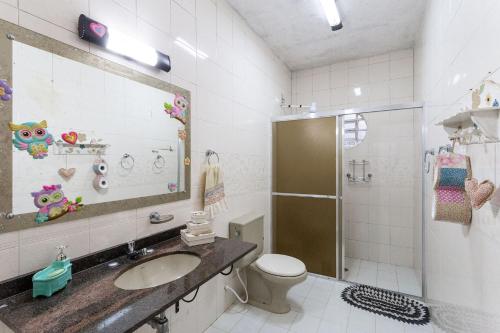 uma casa de banho com um lavatório, um WC e um chuveiro em Casa ampla c/ piscina e churrasqueira em Guararema em Guararema