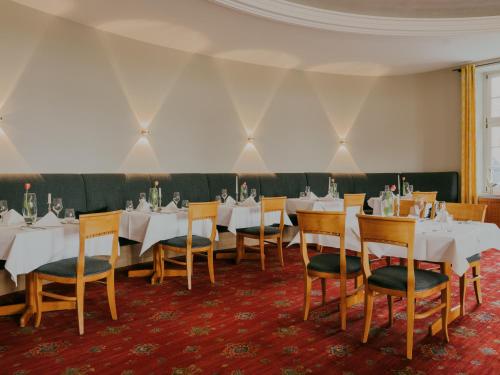 a dining room with white tables and chairs at Bad Hotel Überlingen in Überlingen