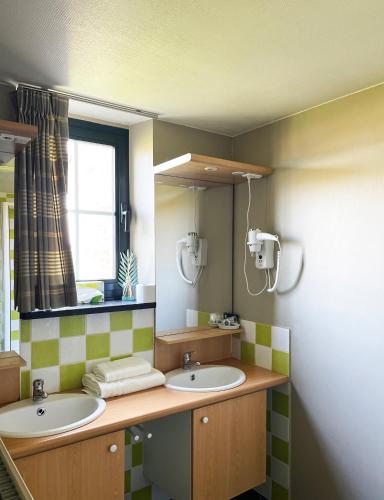 a bathroom with two sinks and a mirror at Hotel het Elsland in Wervik