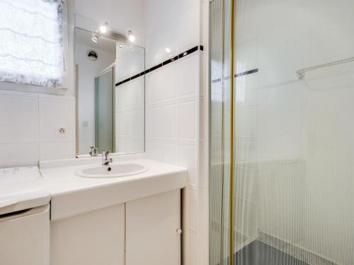 une salle de bain blanche avec un lavabo et une douche dans l'établissement Apartment Astrida by Interhome, à Carnac