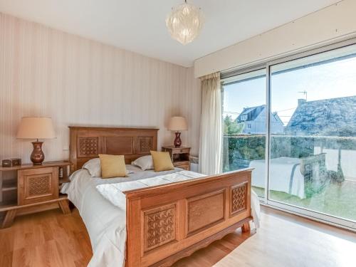 ein Schlafzimmer mit einem Bett und einem großen Fenster in der Unterkunft Holiday Home Grah Moullac by Interhome in Carnac