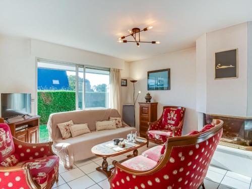 a living room with red chairs and a couch at Holiday Home Grah Moullac by Interhome in Carnac