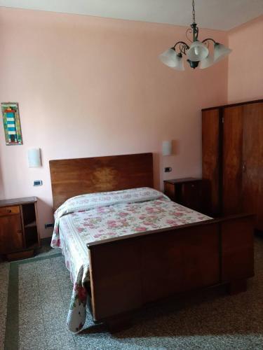 a bedroom with a large bed with a wooden headboard at BeB Angelini dal 1911 in Lucca