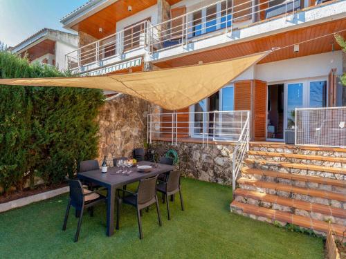 a patio with a table and chairs on the grass at Holiday Home Berganti by Interhome in Tossa de Mar