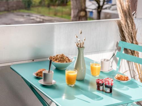a blue table with breakfast foods and orange juice at Apartment Les Pins-3 by Interhome in Carnac
