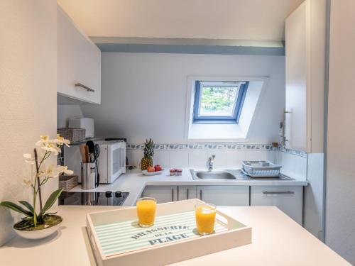 a kitchen with a table with two glasses of orange juice at Apartment Les Pins-3 by Interhome in Carnac