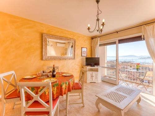 a dining room with a table and a balcony at Apartment Les Pins Dorés-2 by Interhome in Sainte-Maxime