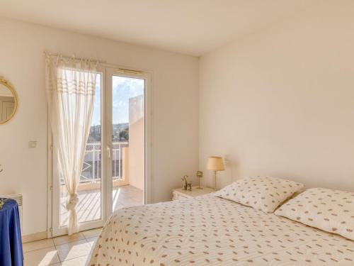 une chambre blanche avec un lit et un balcon dans l'établissement Holiday Home Maxime Park-11 by Interhome, à Sainte-Maxime