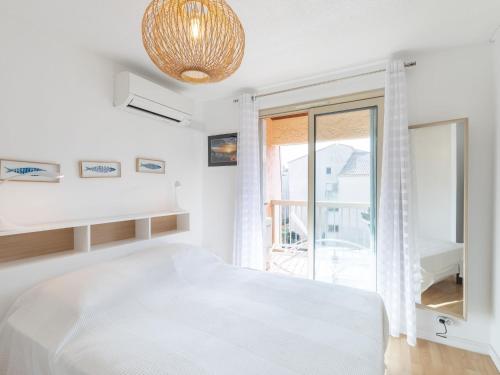une chambre blanche avec un lit et une fenêtre dans l'établissement Apartment Domaine du Préconil-4 by Interhome, à Sainte-Maxime