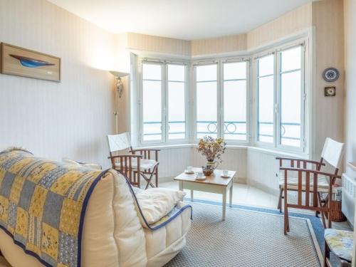 - un salon avec un canapé, une table et des fenêtres dans l'établissement Apartment Les Armateurs by Interhome, à Saint-Malo