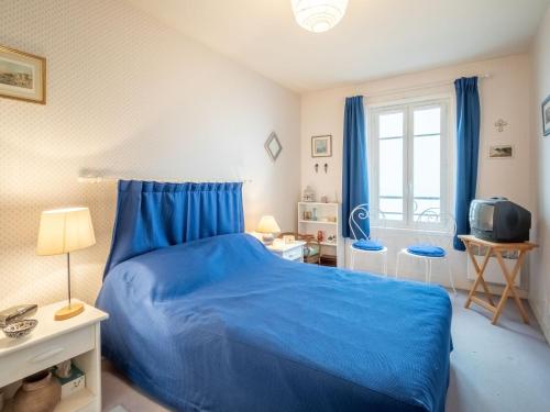 - une chambre avec un lit bleu et des rideaux bleus dans l'établissement Apartment Les Armateurs by Interhome, à Saint-Malo