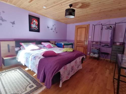 a bedroom with a large bed with purple walls at Chambres D'Hôtes Vosges Chez Sylvia Et Luiggi in Pierrepont