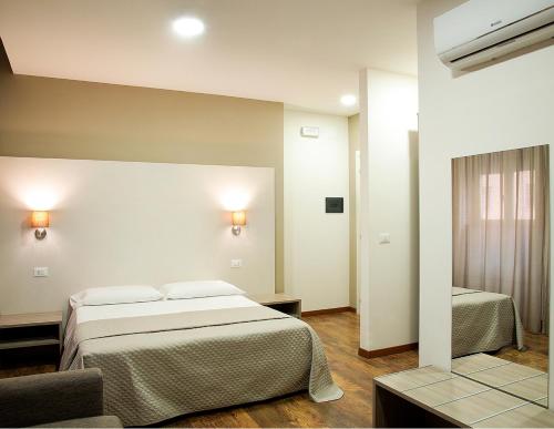 コゼンツァにあるB&B Erifrà Piccolo Hotelのベッドルーム1室(ベッド1台、椅子付)