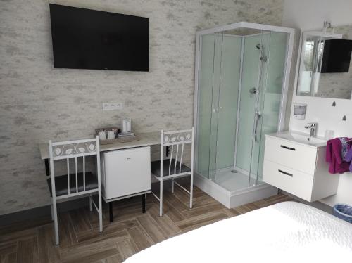 een badkamer met een douche, een bureau en een wastafel bij Chambre HORTENSIA in Questembert