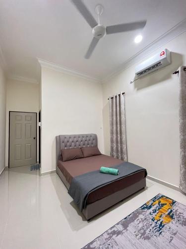 a bedroom with a bed and a ceiling fan at Sofea's Homestay in Kuala Terengganu