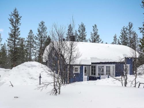 uma casa com um telhado coberto de neve na neve em Holiday Home Sininen maja by Interhome em Saariselka