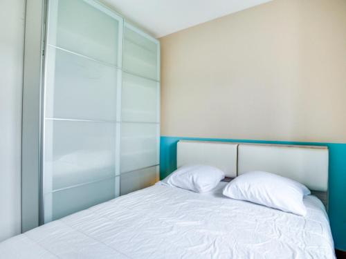 une chambre avec un lit avec deux oreillers blancs dans l'établissement Apartment Le Gambetta by Interhome, à Saint-Malo