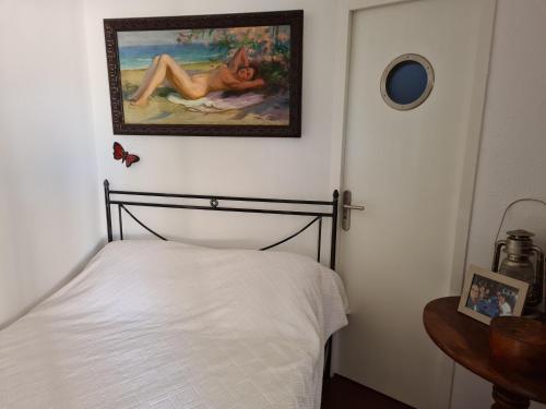 um quarto com uma cama e um quadro na parede em Village des Sables 500 mètres de la Méditerranée. em Torreilles