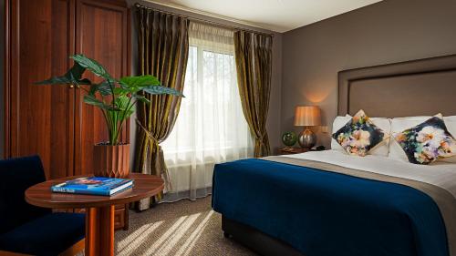 a hotel room with a bed and a table and a window at Longcourt House Hotel in Newcastle West