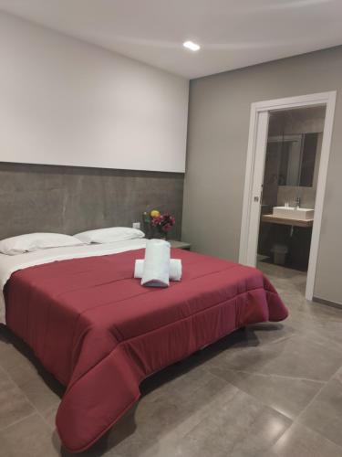 a bedroom with a large red bed with flowers on it at Hotel Valle Verde in Grammichele