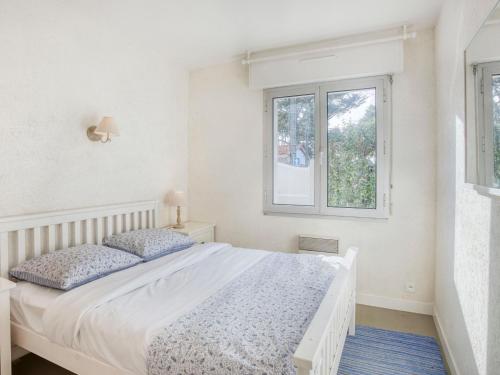 une chambre blanche avec un lit et une fenêtre dans l'établissement Holiday Home Maison Pauline by Interhome, à Carnac