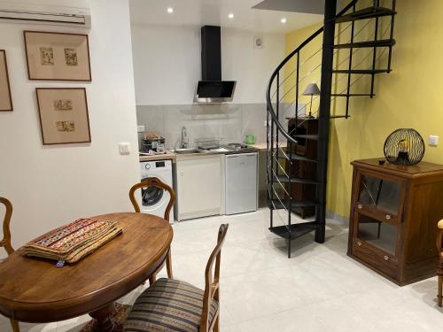a living room with a table and a kitchen at Hostellerie et la parenthese uzes in Uzès