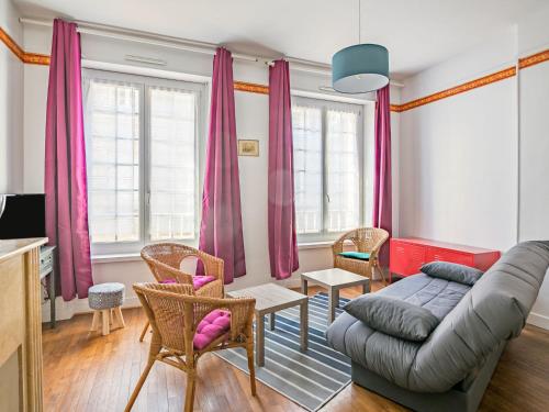 ein Wohnzimmer mit rosa Vorhängen und einem Sofa in der Unterkunft Apartment Broussais by Interhome in Saint-Malo