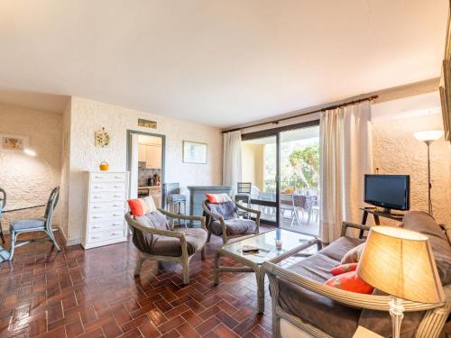 un salon avec un canapé, des chaises et une télévision dans l'établissement Apartment Porto di Mar-14 by Interhome, à Cavalaire-sur-Mer